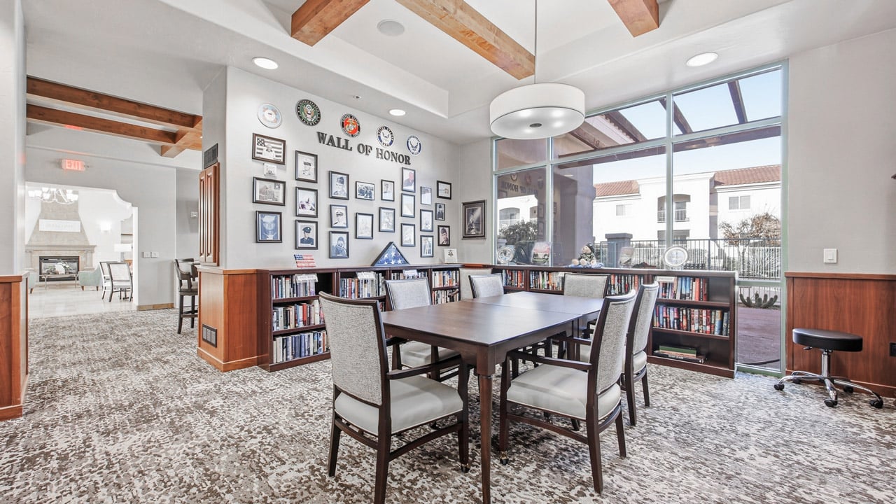 The library at The Peaks at Santa Rita with shelves of books and comfortable seating